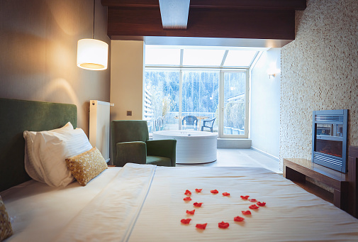 Cozy hotel room with heart shape on bed