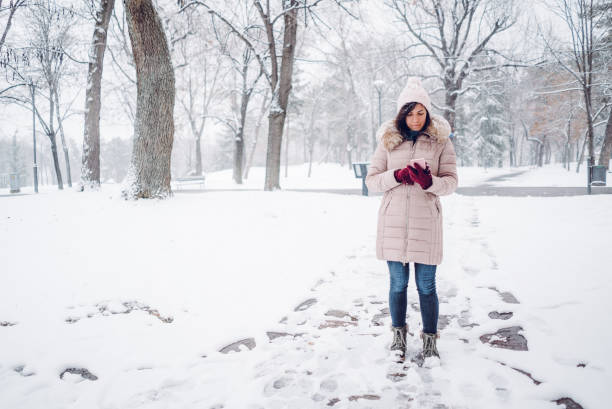 istock Woman using phone in the snow 1092360486