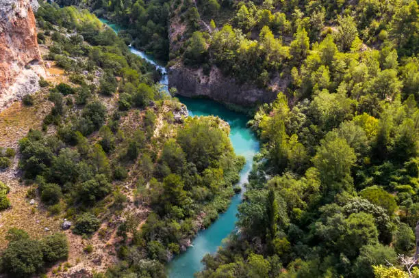 Aerial views of the meander of the river Jucar in Cuenca, Spain. Top view of the beautiful nature of the valley on a sunny day. Drone scene.