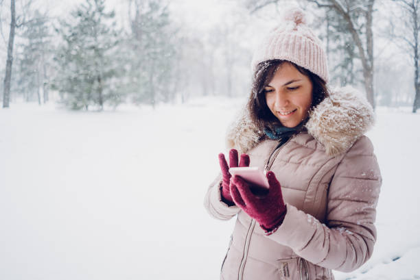 istock Woman using phone in the snow 1092361664