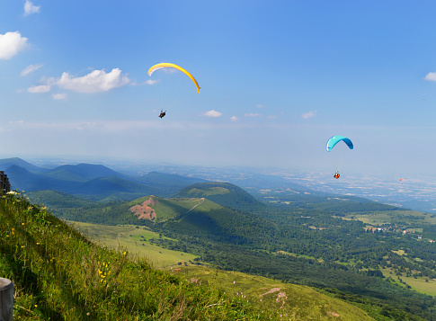 Paragliders who fly in the middle of landscape volcanoes and mountains.
