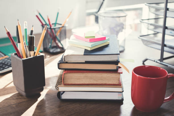 istock Stack of books and office supplies on wood table 1092392760