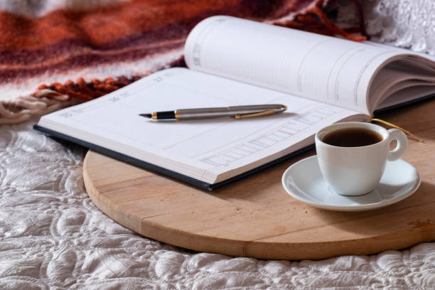 istock Cup with coffee, notepad, pen on the wooden desk on the bed. 1092400274