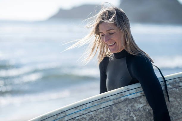 istock A female surfer walking along the beach 1092409176