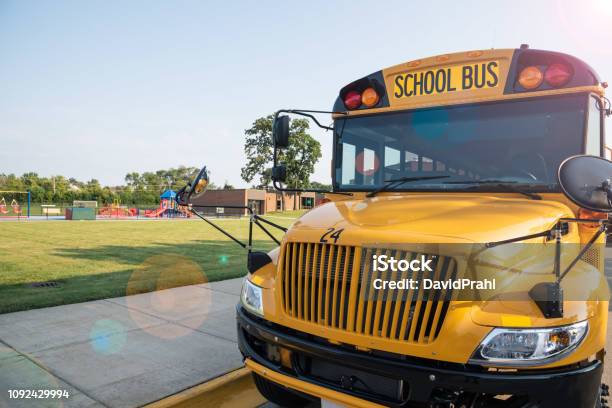 Yellow School Bus Parked Next To Playground Stock Photo - Download Image Now - School Bus, School Building, Field Trip