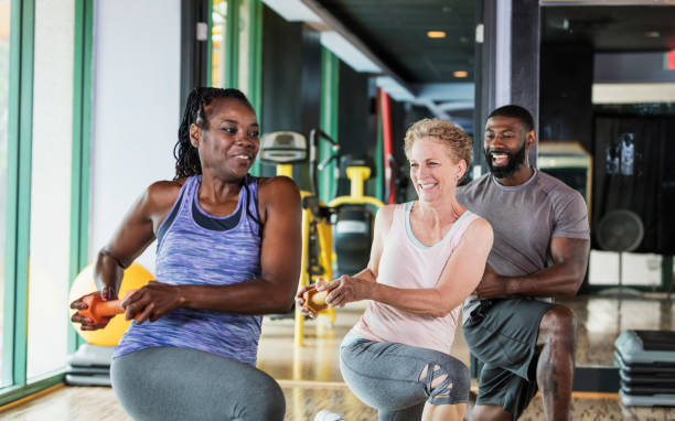 groupe de personnes dans la salle de gym va se fend - men weight training african descent male photos et images de collection