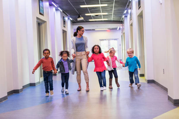 istock Teacher and preschool students walking in hallway 1092434520
