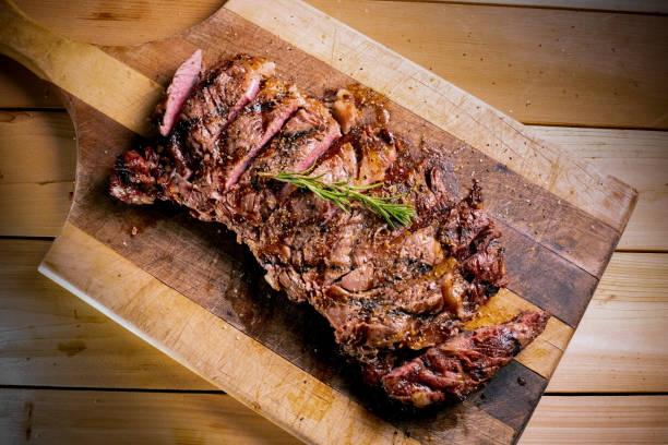 Delicious perfectly cooked ribeye steak sliced up on a cutting board ready to be served
