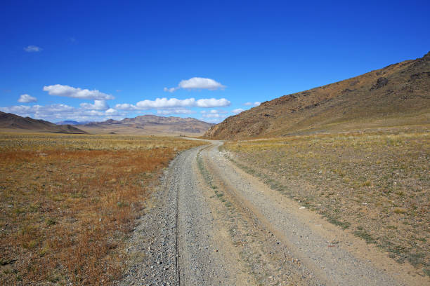 istock The rural road in the desert behind the mountain range at mongolia 1092486882