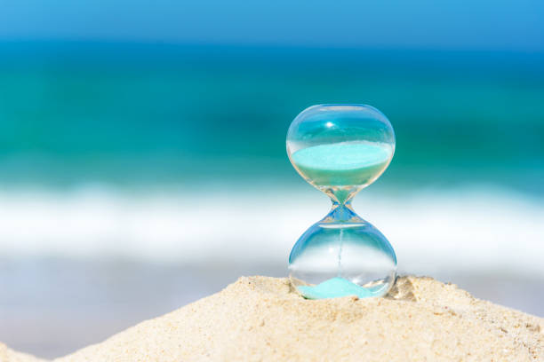青い空とコピー スペースが付いている砂のビーチで砂時計夏と休暇時間。 ライフ スタイルのコンセプト。 - hourglass clock sand countdown ストックフォトと画像
