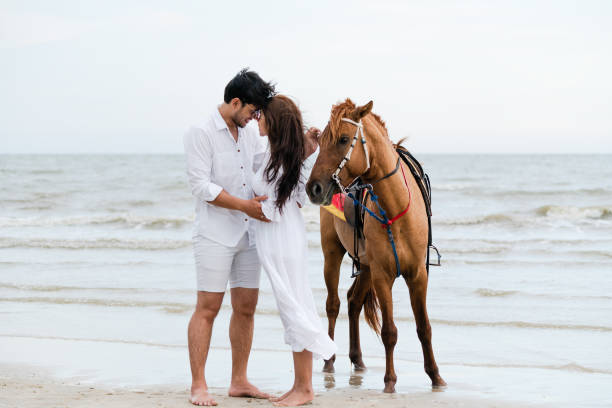istock Young couple goes horse riding on tropical beach. 1092510580
