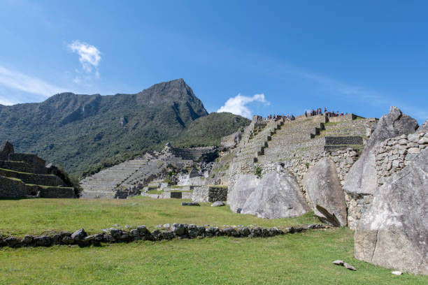 Tourists visting Machu Picchu, the citadel of the Inca Empire located in Peru, South America, during a hot summer morning.