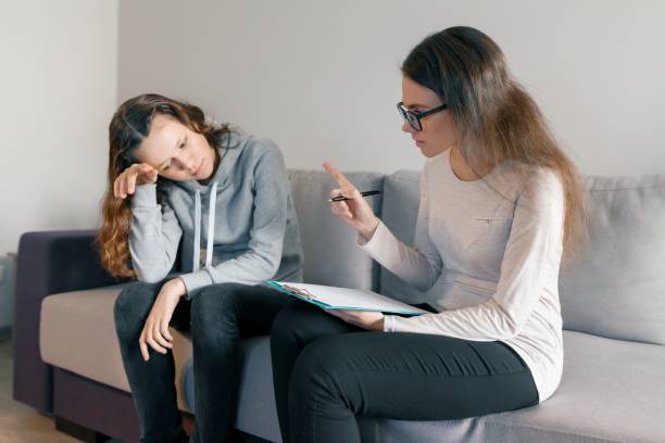 young woman professional psychologist talking with teenager girl 14, 15 years old sitting in office on sofa. mental health of child in adolescence - years 13 14 years teenager old imagens e fotografias de stock