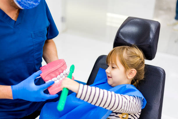 istock Dentist teaching Beautiful girl to proper brush teeth 1092545610