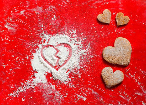 istock Heart broken sign in Valentine's day with white icing flour on red background. 1092560434