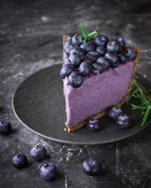 Blueberry vegan cheesecake. Dark photo on black background