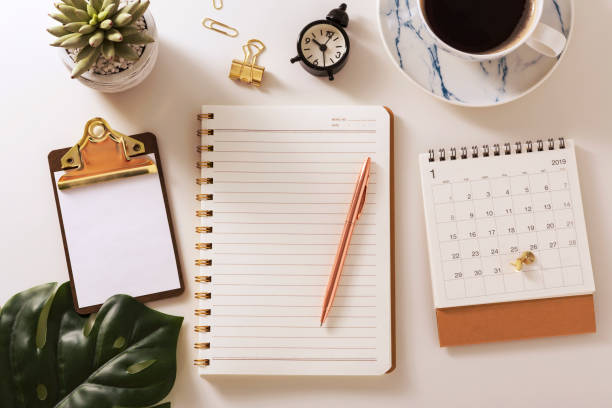 istock Flat lay desk with notebook, coffee, calendar and green leaf 1092570724