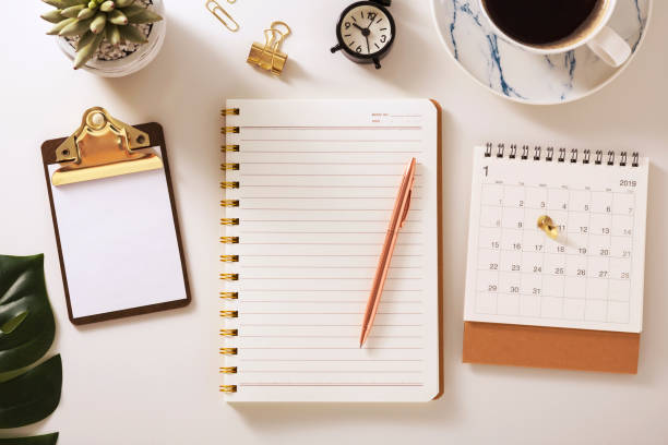 Flat lay desk with notebook and calendar, warm tone