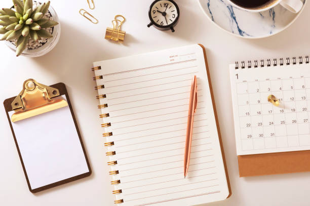 istock Desk with notebook, calendar, clock and plant 1092572332