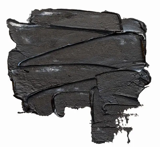 Textured black oil paint brush stroke, isolated on white background.