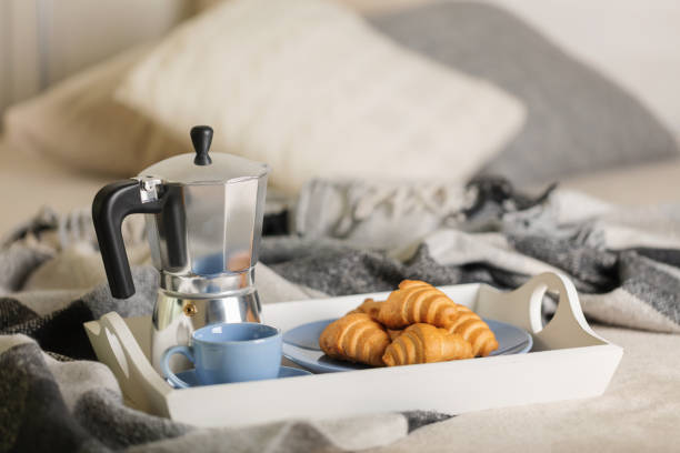 istock Breakfast in bed. On a white tray there is a coffee maker, coffee blue cup and croissants. 1092616380