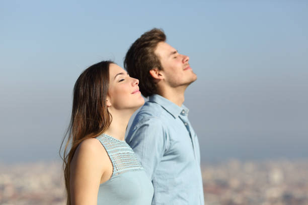 Relaxed couple breathing fresh air with urban background Relaxed couple breathing fresh air with urban background relief emotion stock pictures, royalty-free photos & images