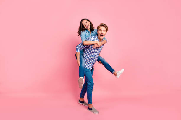 Close up full length body size photo of piggy back hugging she h Close up full length body size photo of piggy back hugging she her he him his lady guy boy going to competitions best team wearing casual jeans denim plaid shirts isolated on rose background happy sibling day stock pictures, royalty-free photos & images