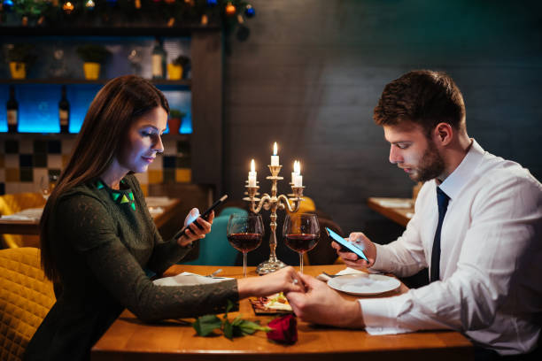 Couple holding hands and texting on the smart phone