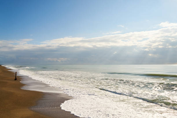 Holidays in France, looking at beams of sunlight touch the water at the beach of Granville, France.