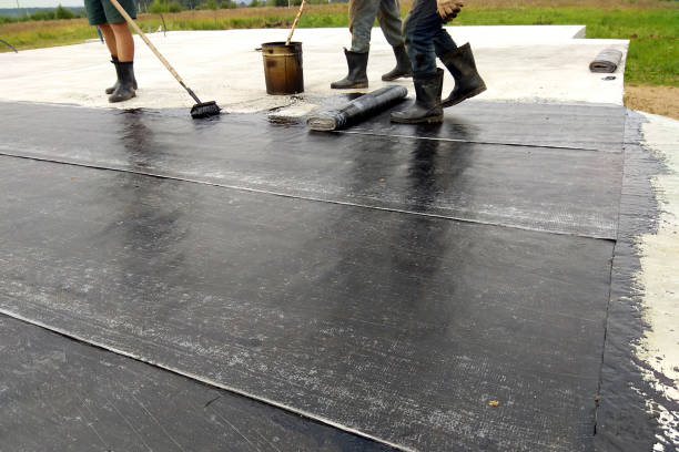 istock Roofer worker painting bitumen praimer at concrete surface by the roller brush Waterproofing 1092635600