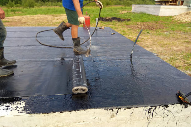 istock Professional installation of waterproofing on the concrete foundation Two worker at construction site. 1092635730