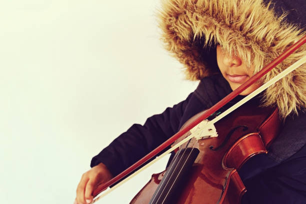 istock A boy with lovely lips playing the stringed and bowed musical instrument, the violin 1092639602