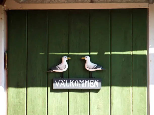 Wooden door with welcome-sign in Swedisch