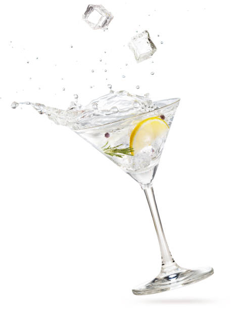 cubetti di ghiaccio che cadono in un gin martini inclinato - martini glass foto e immagini stock