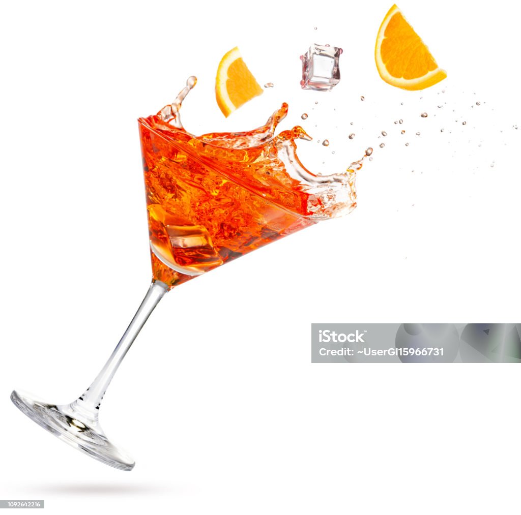 orange slices falling into a tilted splashing cocktail orange and ice cube falling into a splashing martini isolated on white Cocktail Stock Photo