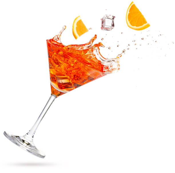 orange slices falling into a tilted splashing cocktail stock photo
