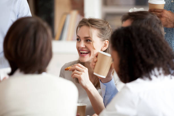 sonriendo empresaria comer pizza con sus colegas de escapada - lunch business office business lunch fotografías e imágenes de stock