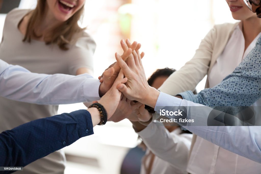 Excited multiracial team giving high five at briefing close up Excited happy multiracial team giving high five, celebrating good results, congratulating with success at briefing, group of employees rejoicing at achieved goal, good teamwork, collaboration, close up High-Five Stock Photo