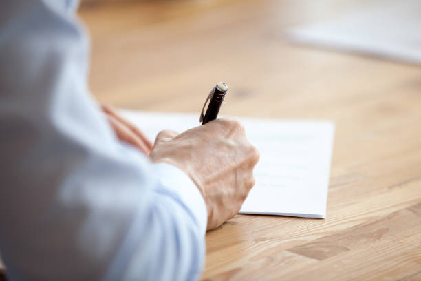 человек рука держа ручку, писать заметки на встрече крупным планом - letter writing handwriting human hand стоковые фото и изображения