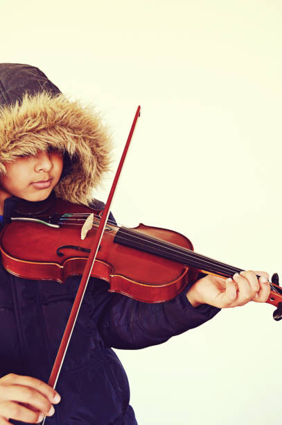 istock Vertical capture of a boy with lovely lips playing the stringed and bowed musical instrument, the violin 1092646706