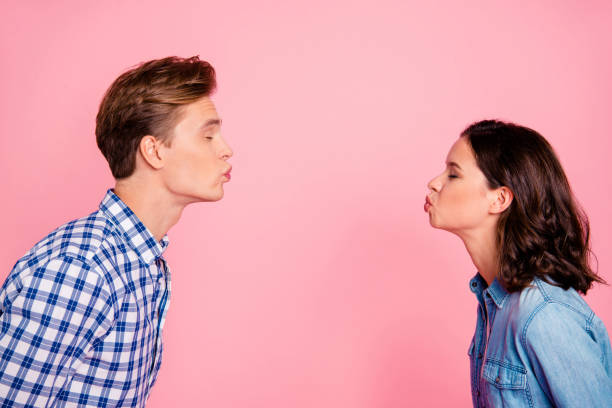 Profile side view portrait of nice sweet charming adorable lovel Profile side view portrait of nice sweet charming adorable lovely attractive flirty couple reaching out to each other closed eyes isolated over pink pastel background kissing stock pictures, royalty-free photos & images