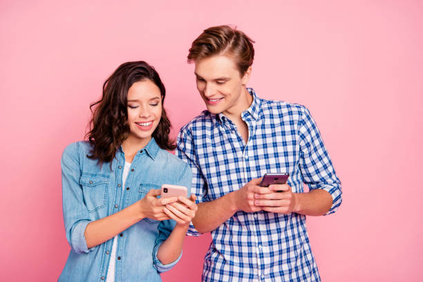 portrait of nice lovely attractive cheerful cheery couple holdin - shirt women pink jeans imagens e fotografias de stock