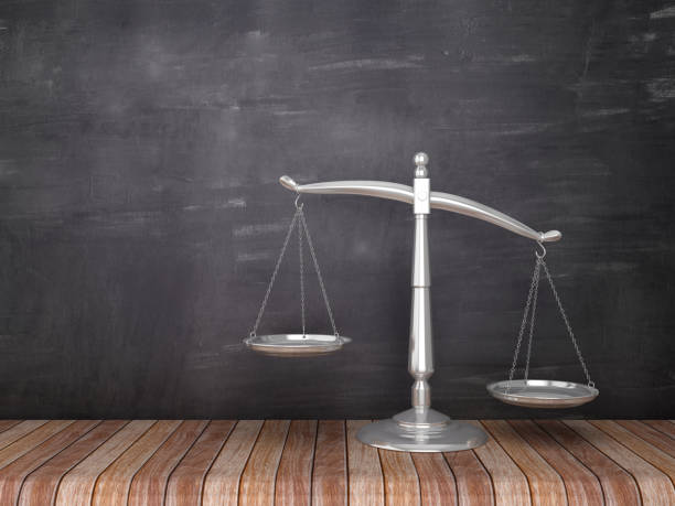 istock Scales of Justice on Wood Floor - Chalkboard Background - 3D Rendering 1092670344