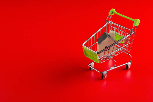 istock a house model in a shopping cart on red background 1092670524