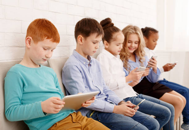 istock Schoolchildren with modern devices near brick wall 1092670732