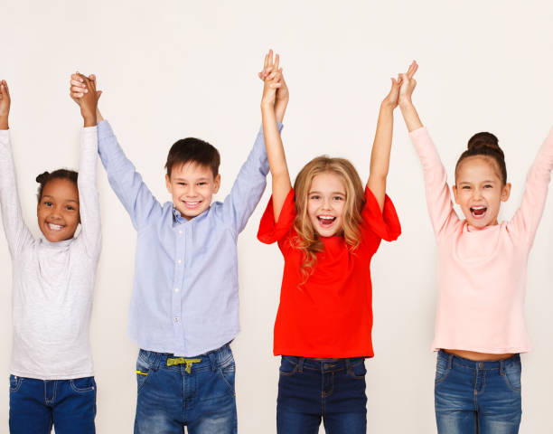 istock Happy kids raised hands, standing in row 1092674548