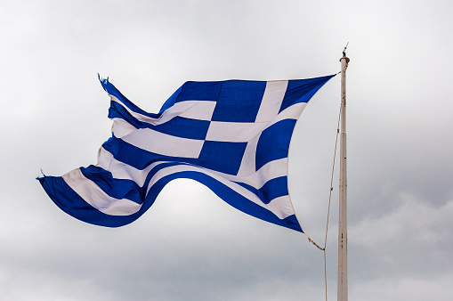Athens, Greece - June 12, 2013: National vibrant blue and white flag of Greece fluttering waving flying in the wind on the flagpole