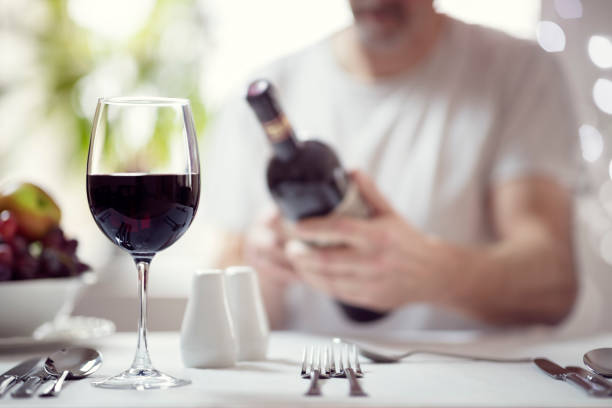 Man reading a wine bottle label in restaurant
