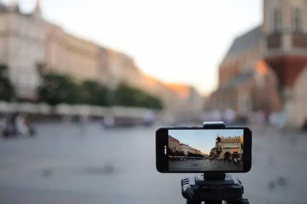 Close-up smartphone take cityscape photo and video timelapse on tripod.