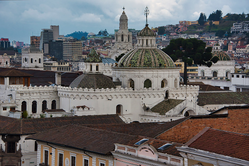 the domes of the historic church of La Compañía are reaching out of the surrounding historic city of Quito